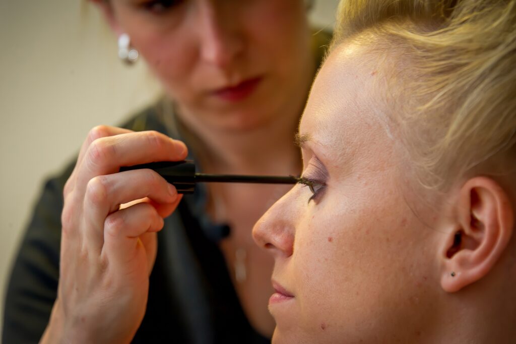 Maquilleuse appliquant du maquillage sur la mariée