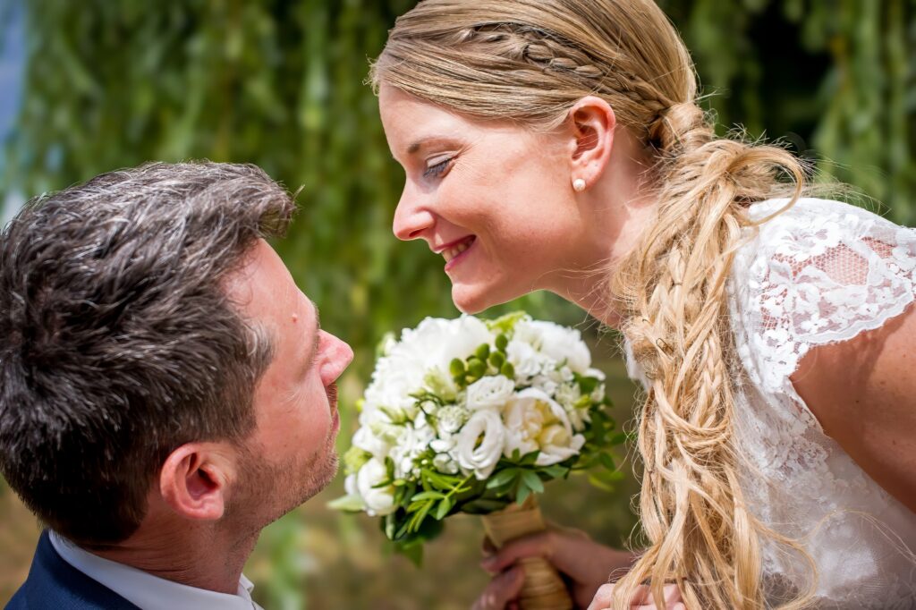 Mariée souriant au marié avec un bouquet