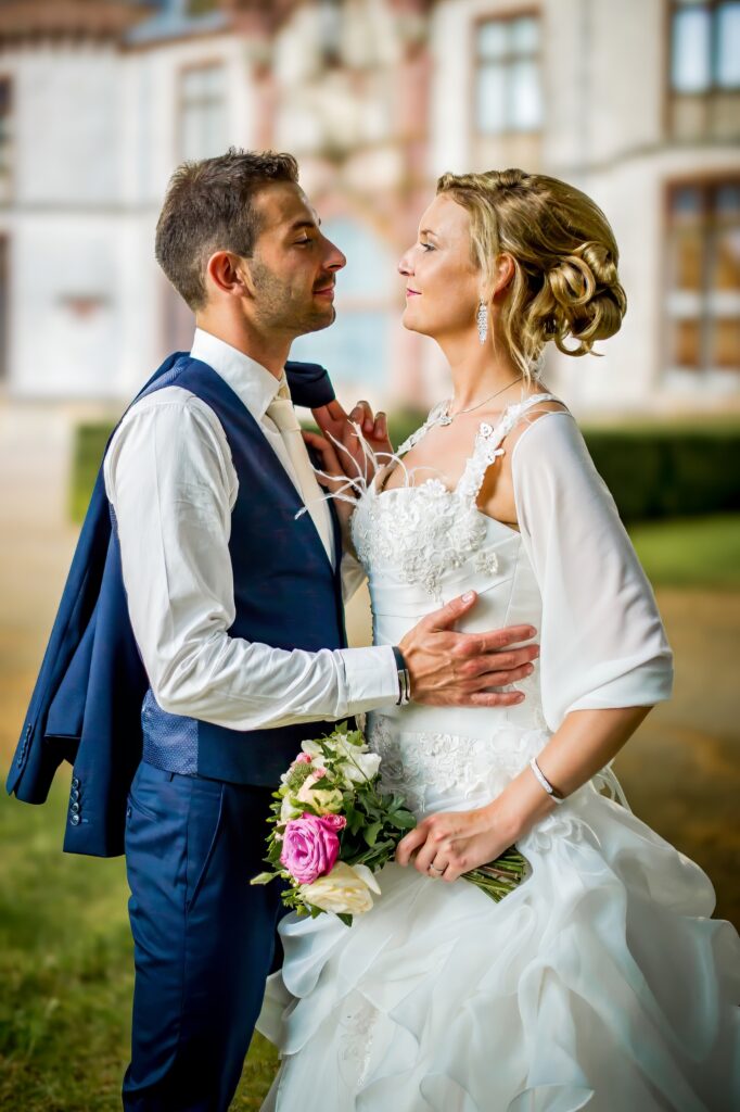 Mariés se regardant tendrement en tenant un bouquet