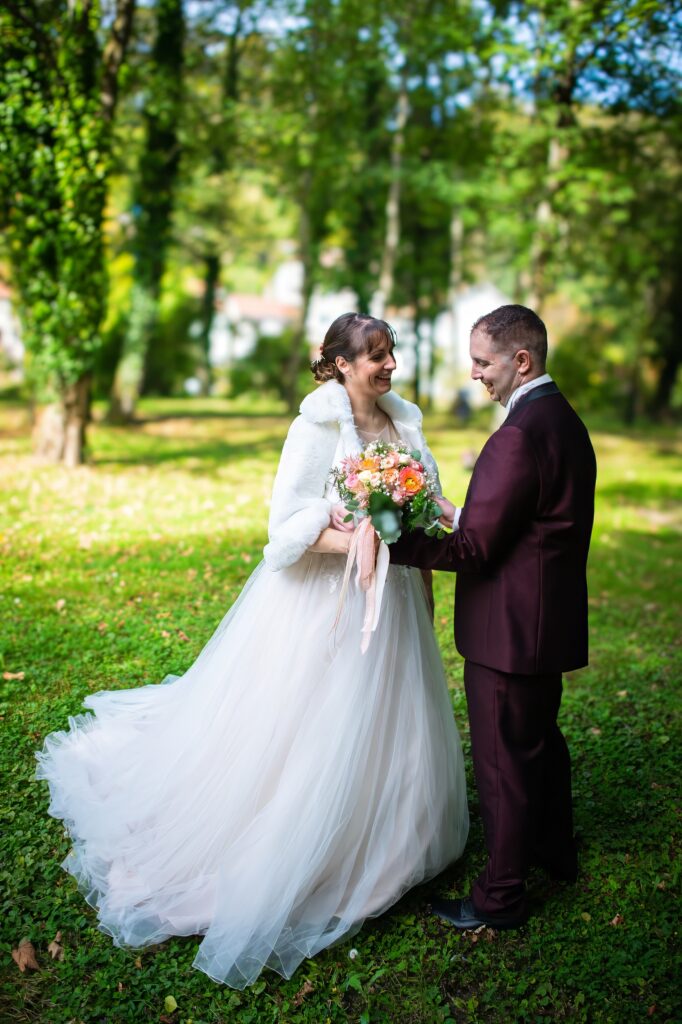 Mariés se tenant la main dans un jardin avec un bouquet