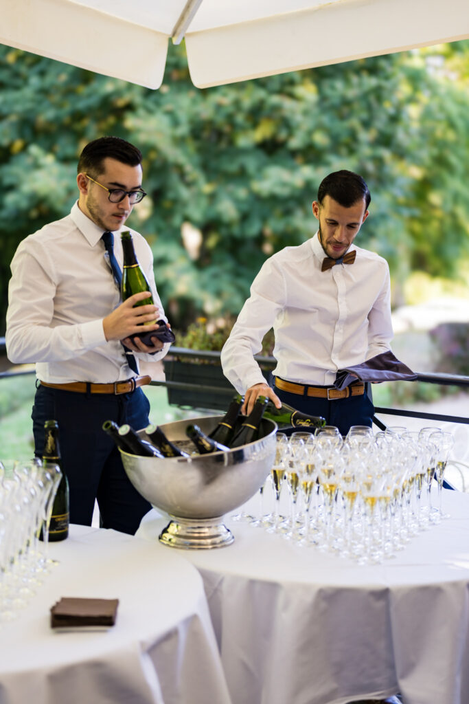 Serveurs préparant les verres de champagne pour le vin d'honneur du mariage