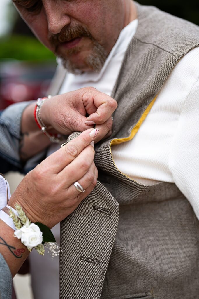 Homme ajustant son costume de mariage, épinglé