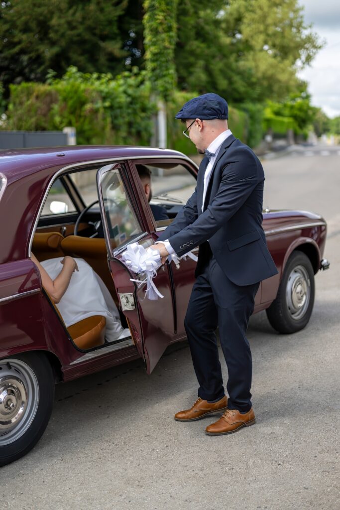 Chauffeur ouvrant la porte de la voiture pour la mariée