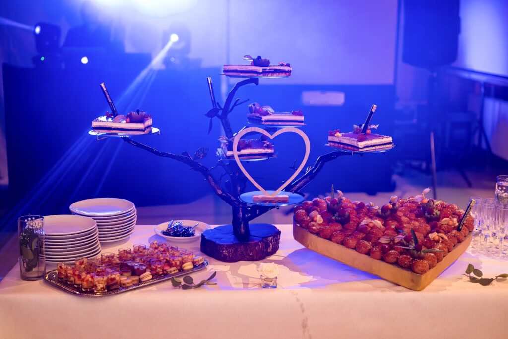 Gâteau de mariage éclairé par des lumières de soirée avec DJ en fond