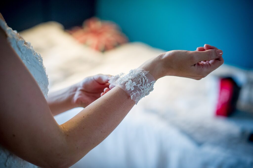 Mariée ajustant un bracelet en dentelle blanche sur son poignet