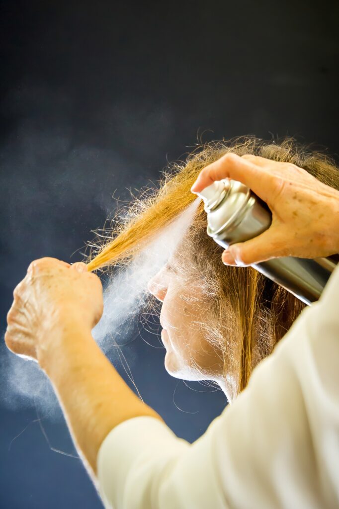 Coiffeuse appliquant de la laque sur les cheveux