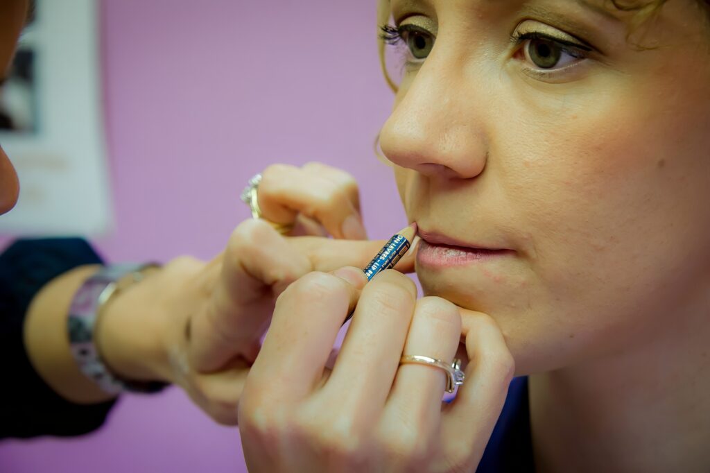 Application du maquillage des lèvres de la mariée avec un pinceau