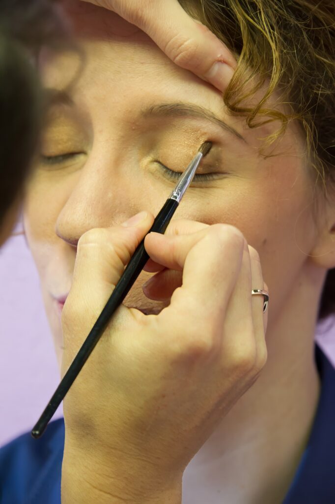 Retouche du maquillage des paupières de la mariée avec un pinceau