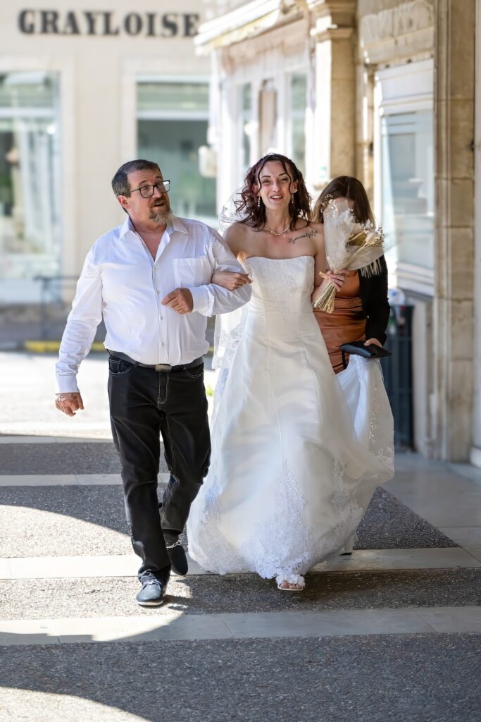 Mariée marchant accompagnée vers son mariage