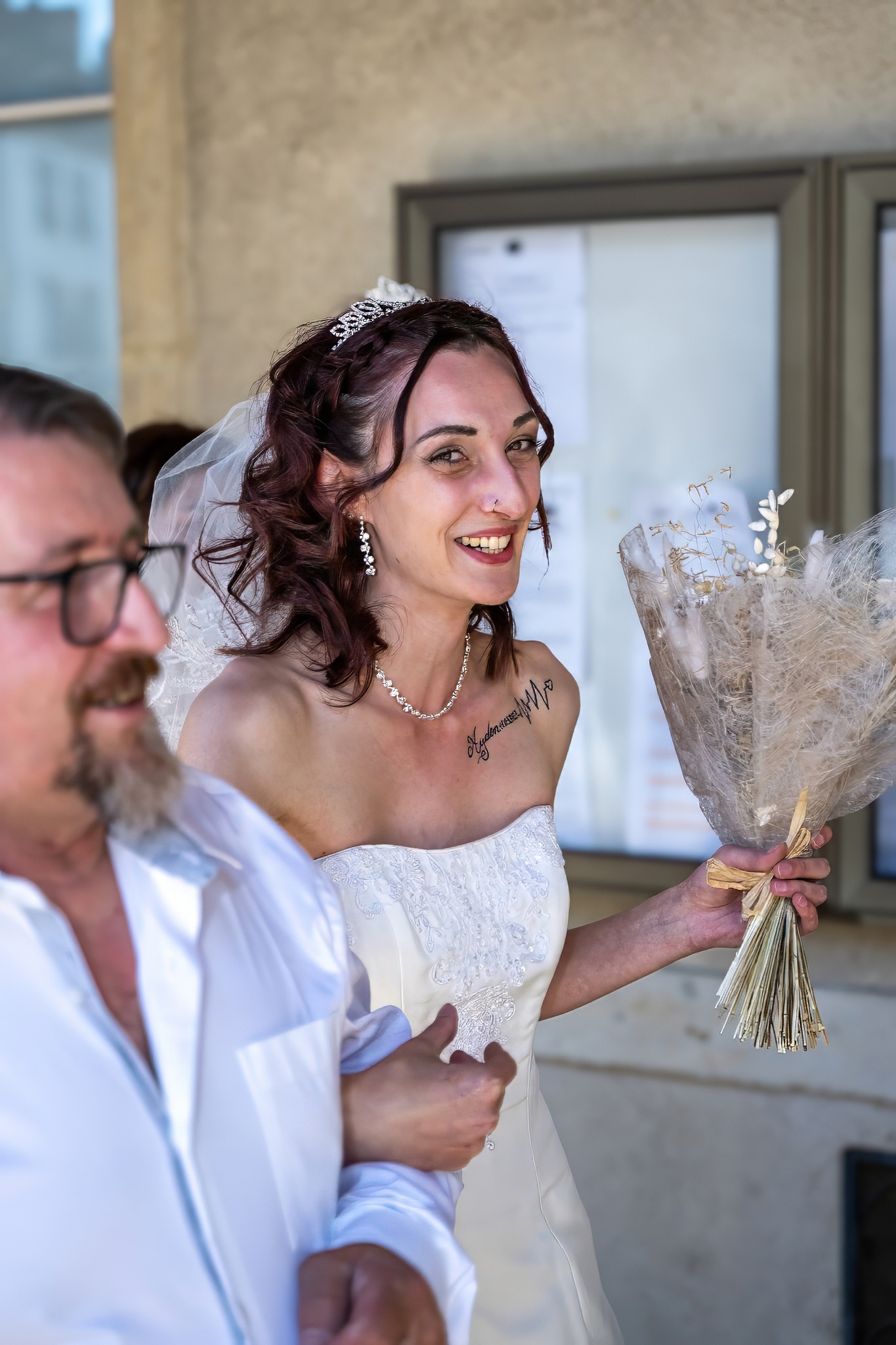 Mariée souriante tenant un bouquet de mariage