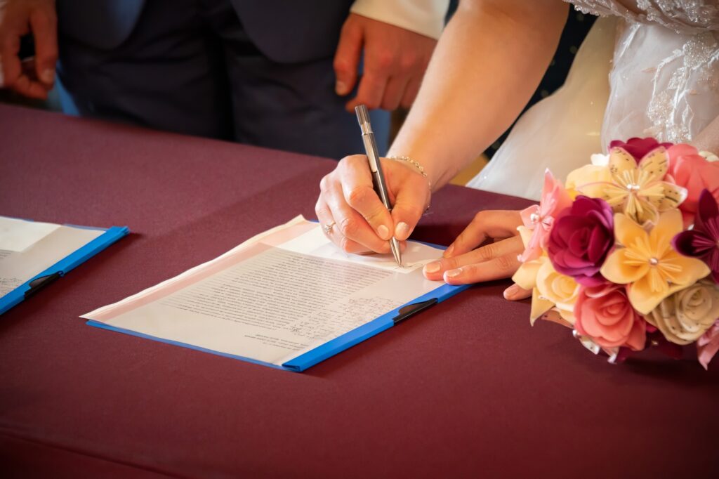 Mariée et marié signant le registre de mariage à la mairie