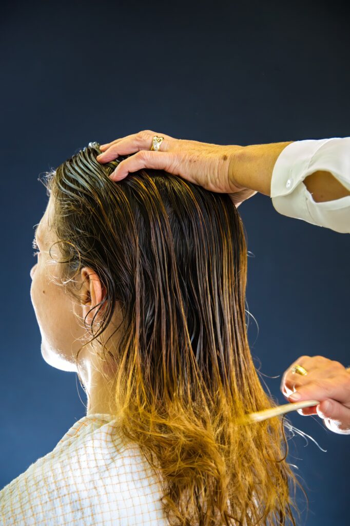 Coiffeuse peignant les cheveux mouillés