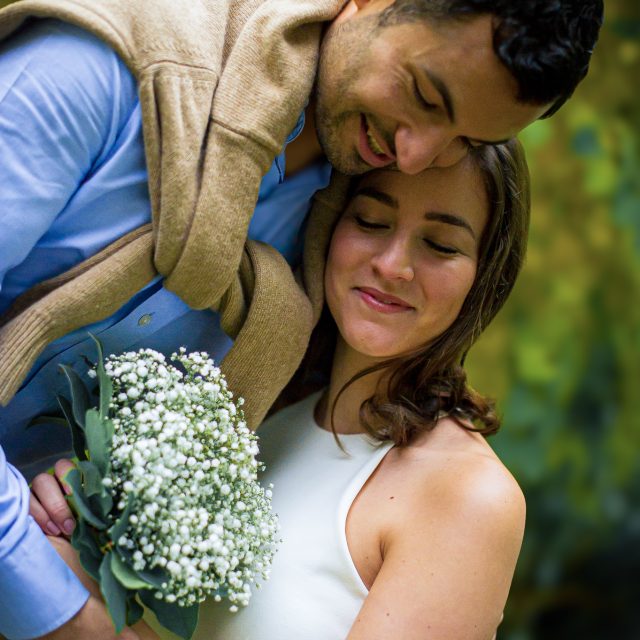 Futurs mariés enlacés avec un bouquet de fleurs